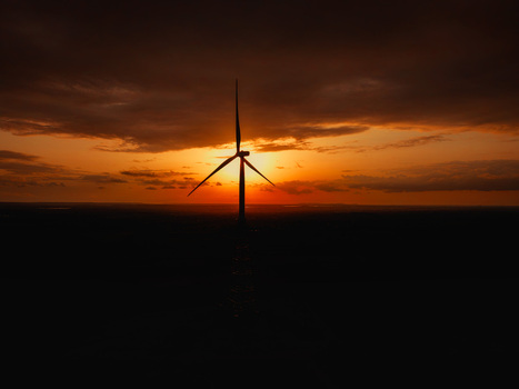 Aerial view of a wind turbine silhouetted against a vibrant sunset sky in Hampi Karnataka India.