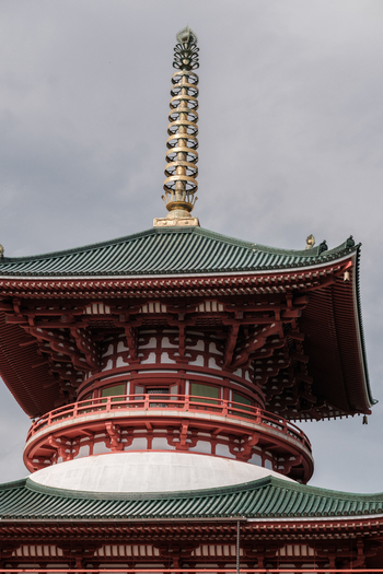 View of the striking red pagoda with its tiered roofs and golden spire reaches towards the cloudy sky an architectural marvel Narita Chiba Japan. View of the striking red pagoda with its tiered roofs and golden spire reaches towards the cloudy sky an architectural marvel Narita Chiba Japan.