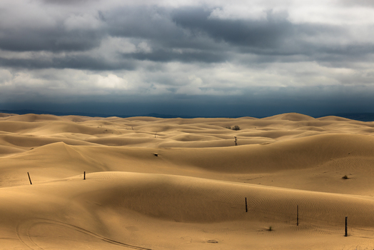 Aerial view of the vast Senek Desert with rolling sand dunes under a dramatic stormy sky Senek Mangystau Region Kazakhstan.