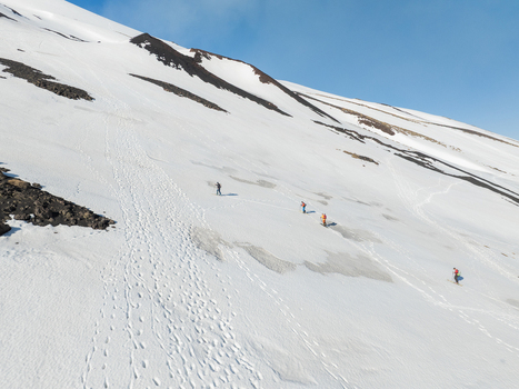 Aerial view of Versante sud dell Etna with people hiking on the snow covered volcanic slope under a clear blue sky Nicolosi Sicilia Italy. Aerial view of Versante sud dell Etna with people hiking on the snow covered volcanic slope under a clear blue sky Nicolosi Sicilia Italy.