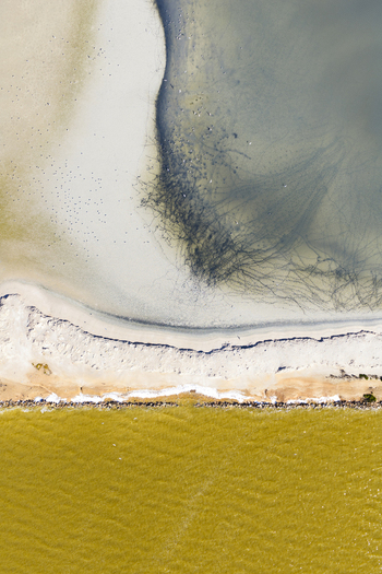 Aerial view of the vibrant yellow salt ponds meeting the serene beach and the tranquil sea a mesmerizing blend of colors and textures San Pedro del Pinatar Region of Murcia Spain. Aerial view of the vibrant yellow salt ponds meeting the serene beach and the tranquil sea a mesmerizing blend of colors and textures San Pedro del Pinatar Region of Murcia Spain.