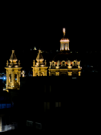 View of golden lights illuminating the intricate architecture of historical buildings against the deep night sky Valletta Malta. View of golden lights illuminating the intricate architecture of historical buildings against the deep night sky Valletta Malta.