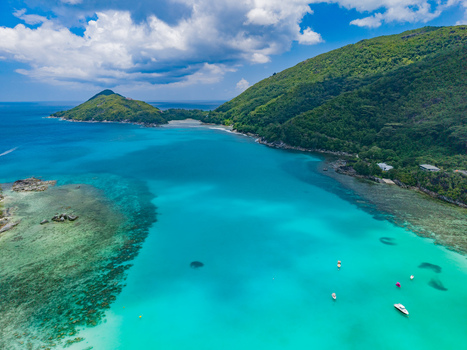 Aerial view of turquoise waters meet lush green hills and small boats dotting the bay revealing a tropical paradise. Victoria Mahe Island Seychelles. Aerial view of turquoise waters meet lush green hills and small boats dotting the bay revealing a tropical paradise. Victoria Mahe Island Seychelles.