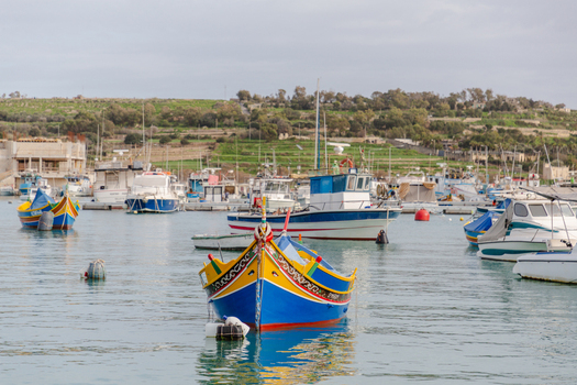 View of vibrant traditional Maltese fishing boats known as Luzzus bob gently on the tranquil azure waters of the harbor Marsaxlokk Malta. View of vibrant traditional Maltese fishing boats known as Luzzus bob gently on the tranquil azure waters of the harbor Marsaxlokk Malta.