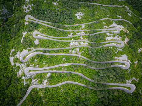Aerial view of the winding Kotor Serpentine road with its sharp hairpin turns cutting through the lush green mountainside in Kotor Kotor Municipality Montenegro. Aerial view of the winding Kotor Serpentine road with its sharp hairpin turns cutting through the lush green mountainside in Kotor Kotor Municipality Montenegro.
