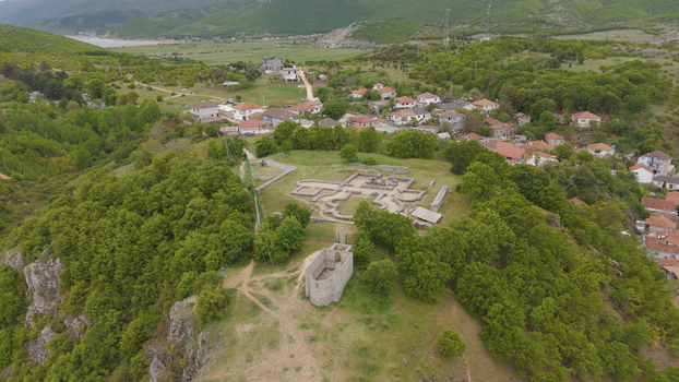 Aerial view of the historic Lin Basilica ruins situated on a lush green hill overlooking the village of Lin surrounded by dense trees in Lin Korce County Albania.