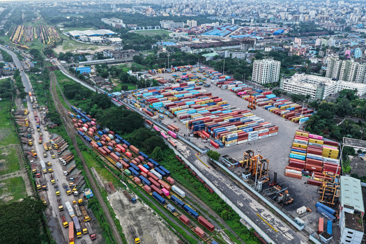 Aerial view of Chattogram Port featuring rows of colorful shipping containers freight trains on tracks and industrial cranes in Chittagong Chittagong Division Bangladesh.