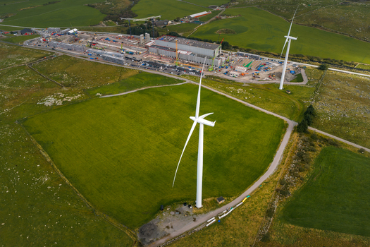 Aerial view of the Green Mountain SVG Undheim Datasenter facility with large wind turbines in the surrounding green fields and rural landscape in Undheim Rogaland Norway. Aerial view of the Green Mountain SVG Undheim Datasenter facility with large wind turbines in the surrounding green fields and rural landscape in Undheim Rogaland Norway.