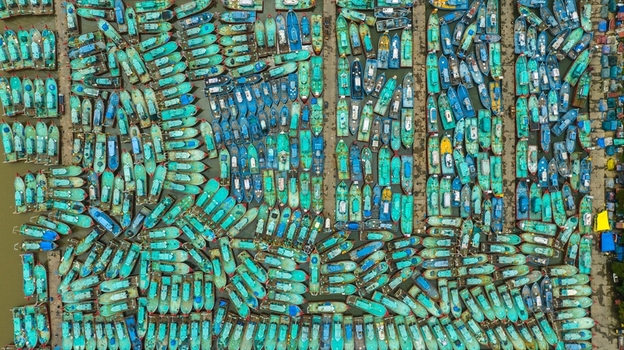 Aerial view of Malpe Fishing Harbour with numerous colorful fishing boats docked in organized rows in Udupi Karnataka India. Aerial view of Malpe Fishing Harbour with numerous colorful fishing boats docked in organized rows in Udupi Karnataka India.