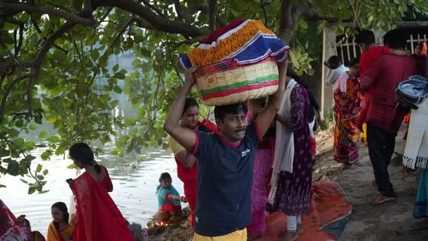 View of a man carrying a basket on his head by a river Bangladesh. View of a man carrying a basket on his head by a river Bangladesh.