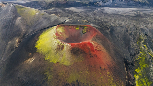 Aerial view of the vibrant red and green Raudaskal crater surrounded by dark volcanic landscape in Rangarthing ytra Iceland. Aerial view of the vibrant red and green Raudaskal crater surrounded by dark volcanic landscape in Rangarthing ytra Iceland.