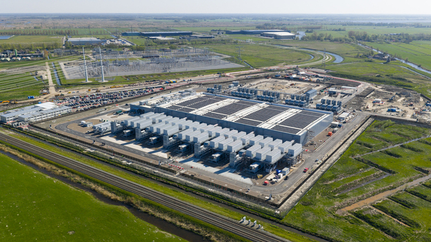 Aerial view of Datacenter Westpoort featuring cooling units and solar panels on the roof surrounded by green fields in Groningen Groningen Netherlands. Aerial view of Datacenter Westpoort featuring cooling units and solar panels on the roof surrounded by green fields in Groningen Groningen Netherlands.