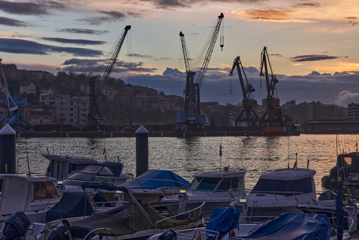 Pasai Donibane Spain 09 March 2026 View of Puerto Pasajes with industrial cranes silhouetted against a sunset sky and small boats moored in the harbor. Pasai Donibane Spain 09 March 2026 View of Puerto Pasajes with industrial cranes silhouetted against a sunset sky and small boats moored in the harbor.