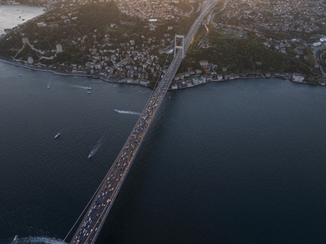 Aerial view of Fatih Sultan Mehmet Bridge spanning the Bosphorus with heavy traffic and urban coastline at sunset in Beykoz Istanbul Turkiye. Aerial view of Fatih Sultan Mehmet Bridge spanning the Bosphorus with heavy traffic and urban coastline at sunset in Beykoz Istanbul Turkiye.