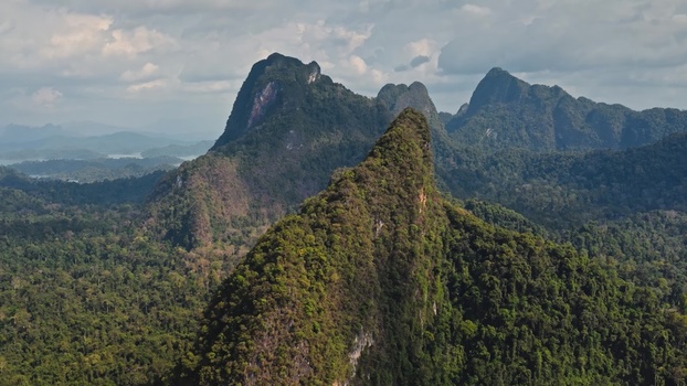 Aerial view of Khao Sok National Park with lush green limestone karst mountains dense rainforest and dramatic peaks in Surat Thani Surat Thani Thailand. Aerial view of Khao Sok National Park with lush green limestone karst mountains dense rainforest and dramatic peaks in Surat Thani Surat Thani Thailand.