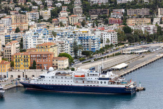Aerial view of a cruise ship docked in the harbor with urban buildings and coastal scenery in Nice Provence Alpes Cote d Azur France. Aerial view of a cruise ship docked in the harbor with urban buildings and coastal scenery in Nice Provence Alpes Cote d Azur France.