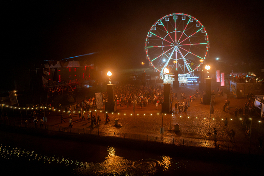 Herzogenaurach Germany 26 July 2025 Aerial view of Open Beatz Festival with a lit ferris wheel crowds of people and glowing stage lights at night.