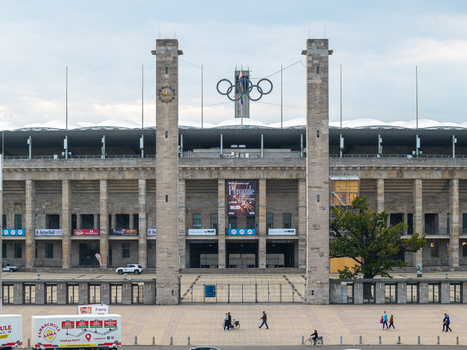 Berlin Germany 26 September 2026 Aerial view of the historic Olympiastadion Berlin featuring its iconic stone columns the Olympic rings and the expansive plaza with people walking below.