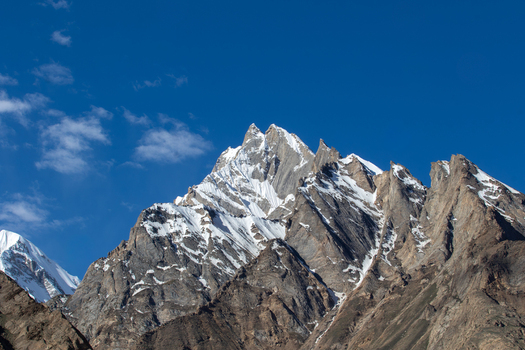 View of a jagged snow capped mountain peak rising against a clear blue sky in the Karakoram range Gilgit Pakistan. View of a jagged snow capped mountain peak rising against a clear blue sky in the Karakoram range Gilgit Pakistan.