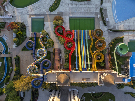 Aerial view of a vibrant water park featuring colorful twisting water slides multiple swimming pools and manicured landscaping Bulgaria. Aerial view of a vibrant water park featuring colorful twisting water slides multiple swimming pools and manicured landscaping Bulgaria.