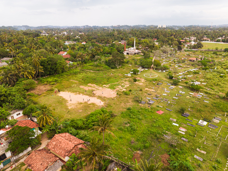 Aerial view of Dadalla Cemetery and mosque surrounded by lush tropical greenery and residential rooftops in Galle Southern Province Sri Lanka. Aerial view of Dadalla Cemetery and mosque surrounded by lush tropical greenery and residential rooftops in Galle Southern Province Sri Lanka.