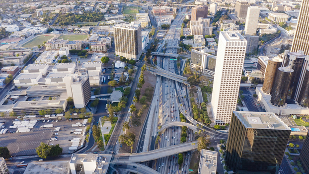 Aerial view of the busy 110 and 101 freeway interchange in downtown Los Angeles featuring multi level highway lanes and modern skyscrapers in Los Angeles California United States.