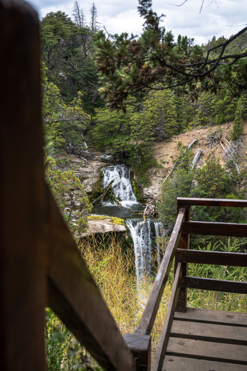 View of Cascada Nant y Fall cascading through a lush forest seen from a wooden observation platform in Trevelin Chubut Argentina. View of Cascada Nant y Fall cascading through a lush forest seen from a wooden observation platform in Trevelin Chubut Argentina.