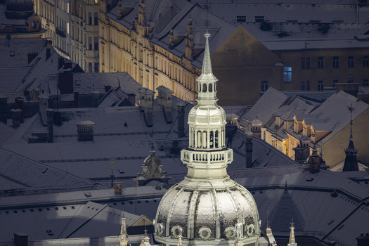 View of snow dusted rooftops and the ornate dome of a city hall tower bathed in the soft glow of a winter s morning in Graz Styria Austria. View of snow dusted rooftops and the ornate dome of a city hall tower bathed in the soft glow of a winter s morning in Graz Styria Austria.