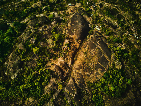Aerial view of the rugged sun kissed cliffs contrasting with the vibrant green vegetation a tapestry of nature s artistry Idanre Ondo Nigeria. Aerial view of the rugged sun kissed cliffs contrasting with the vibrant green vegetation a tapestry of nature s artistry Idanre Ondo Nigeria.