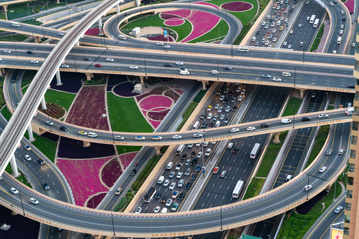 View of a complex multi level highway interchange with heavy traffic metro tracks and decorative landscaped gardens Dubai Dubai United Arab Emirates. View of a complex multi level highway interchange with heavy traffic metro tracks and decorative landscaped gardens Dubai Dubai United Arab Emirates.