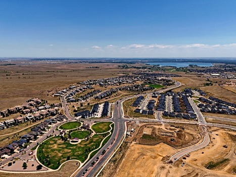 Aerial view of the Leyden suburban development featuring residential neighborhoods a park with green lawns winding roads and surrounding open plains in Jefferson County Colorado United States. Aerial view of the Leyden suburban development featuring residential neighborhoods a park with green lawns winding roads and surrounding open plains in Jefferson County Colorado United States.