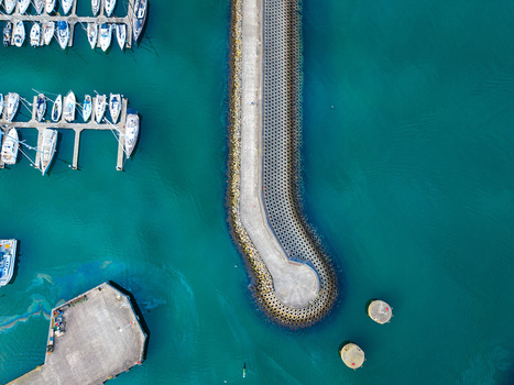 Aerial view of Bangor Harbour and Town with sailboats moored in the marina a concrete breakwater and turquoise water in Bangor Northern Ireland United Kingdom.