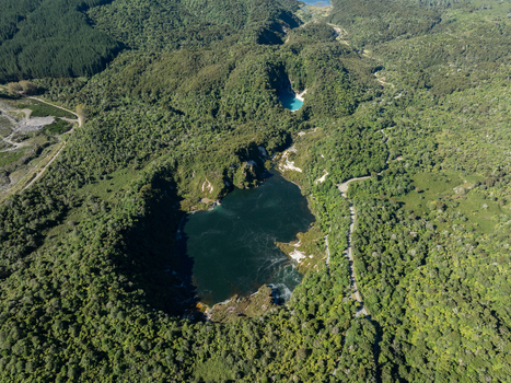 Aerial view of the dark lake nestled within the verdant embrace of dense forest contrasting with the bright turquoise lake in the distance Waimangu Bay of Plenty Region New Zealand. Aerial view of the dark lake nestled within the verdant embrace of dense forest contrasting with the bright turquoise lake in the distance Waimangu Bay of Plenty Region New Zealand.