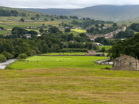 View of the lush green rolling hills and traditional stone walls of the Yorkshire Dales countryside near Hawes England United Kingdom. View of the lush green rolling hills and traditional stone walls of the Yorkshire Dales countryside near Hawes England United Kingdom.