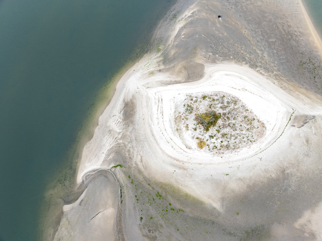Aerial view of the unique eye shaped sandbank and white sand dunes of the Aveiro Lagoon surrounded by calm waters Aveiro Aveiro District Portugal. Aerial view of the unique eye shaped sandbank and white sand dunes of the Aveiro Lagoon surrounded by calm waters Aveiro Aveiro District Portugal.