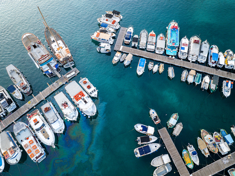 Aerial view of boats docked in the harbor their bright hulls contrasting with the deep blue sea Mgarr Harbour Gozo Malta. Aerial view of boats docked in the harbor their bright hulls contrasting with the deep blue sea Mgarr Harbour Gozo Malta.