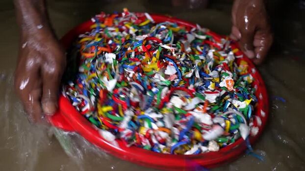 View of worker washing shredded plastic in a basin Bangladesh. View of worker washing shredded plastic in a basin Bangladesh.