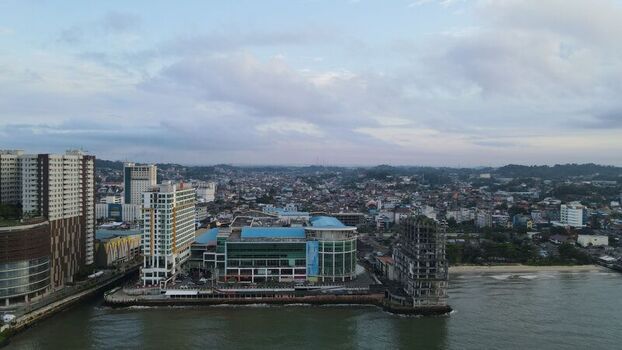 Aerial view of modern high rise buildings a shopping complex and an unfinished structure along the shoreline in Balikpapan East Kalimantan Indonesia. Aerial view of modern high rise buildings a shopping complex and an unfinished structure along the shoreline in Balikpapan East Kalimantan Indonesia.