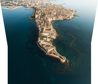 Aerial view of the Island of Ortigia and Maniace Castle surrounded by the calm blue Mediterranean Sea in Syracuse Sicily Italy. Aerial view of the Island of Ortigia and Maniace Castle surrounded by the calm blue Mediterranean Sea in Syracuse Sicily Italy.