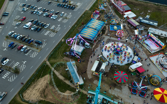 Aerial view of an amusement park with various rides including a carousel roller coaster and spinning attractions situated next to a parking lot in Vilnius Vilnius County Lithuania. Aerial view of an amusement park with various rides including a carousel roller coaster and spinning attractions situated next to a parking lot in Vilnius Vilnius County Lithuania.