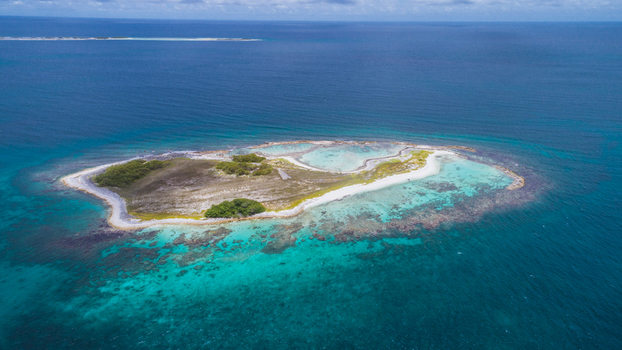 Aerial view of Los Roques archipelago with white sand beaches turquoise coral reefs and lush vegetation in the Caribbean sea Los Roques Dependencias Federales Venezuela. Aerial view of Los Roques archipelago with white sand beaches turquoise coral reefs and lush vegetation in the Caribbean sea Los Roques Dependencias Federales Venezuela.