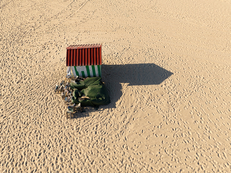 Aerial view of a small striped beach hut with a red roof and stacked chairs on the vast sandy expanse of Praia do Relogio Figueira da Foz Coimbra District Portugal.
