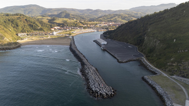 Aerial view of Antilla beach with its long breakwater harbor entrance and surrounding green hills in Gipuzkoa Basque Country Spain.