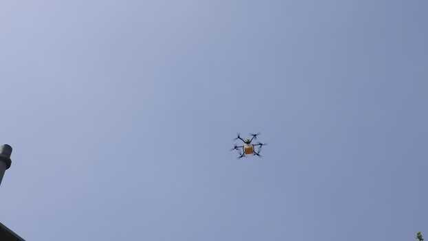 View of a delivery drone flying in the sky China. View of a delivery drone flying in the sky China.