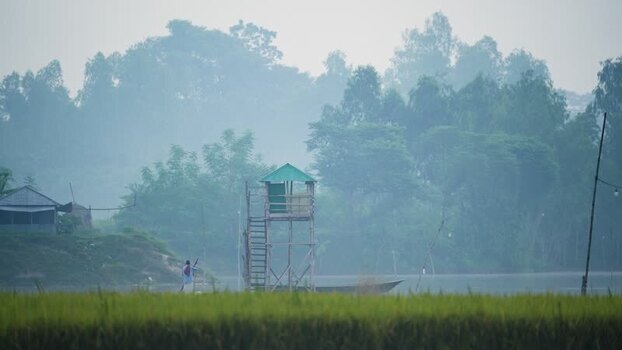 View of a wooden watchtower by a river in Bogura Bangladesh.