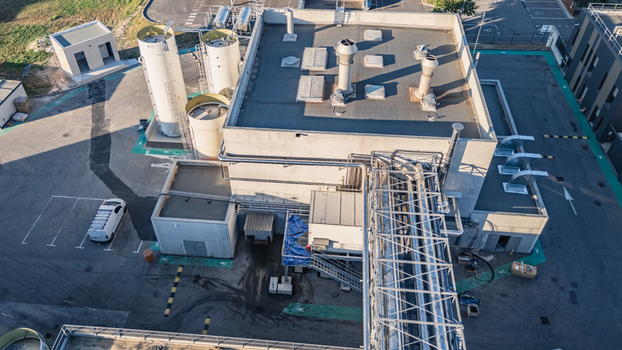 Aerial view of an industrial processing plant featuring rooftop ventilation storage tanks and complex piping infrastructure in the facility yard in Le Pouzin Auvergne Rhone Alpes France.