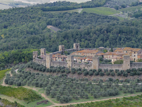 Aerial view of the medieval fortified town of Monteriggioni with its stone walls and towers surrounded by olive groves and vineyards in the Tuscan countryside Monteriggioni Tuscany Italy.