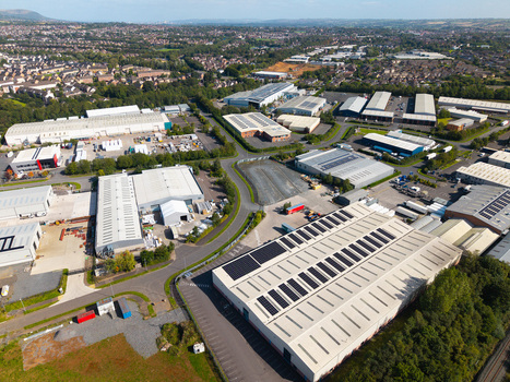Aerial view of an industrial park featuring large warehouses with solar panels on rooftops surrounded by roads and residential neighborhoods in Lisburn Northern Ireland United Kingdom. Aerial view of an industrial park featuring large warehouses with solar panels on rooftops surrounded by roads and residential neighborhoods in Lisburn Northern Ireland United Kingdom.