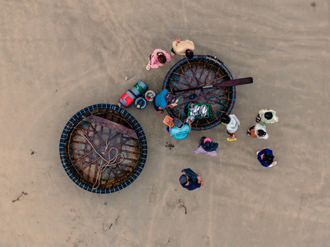 Aerial view of fishermen working with traditional basket boats on a sandy beach in Vietnam. Aerial view of fishermen working with traditional basket boats on a sandy beach in Vietnam.
