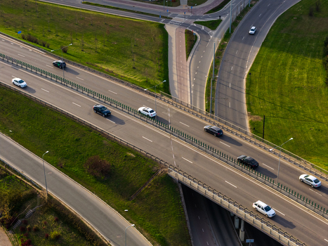Aerial view of cars driving on a multi level highway interchange with green grassy embankments Vilnius County Lithuania. Aerial view of cars driving on a multi level highway interchange with green grassy embankments Vilnius County Lithuania.